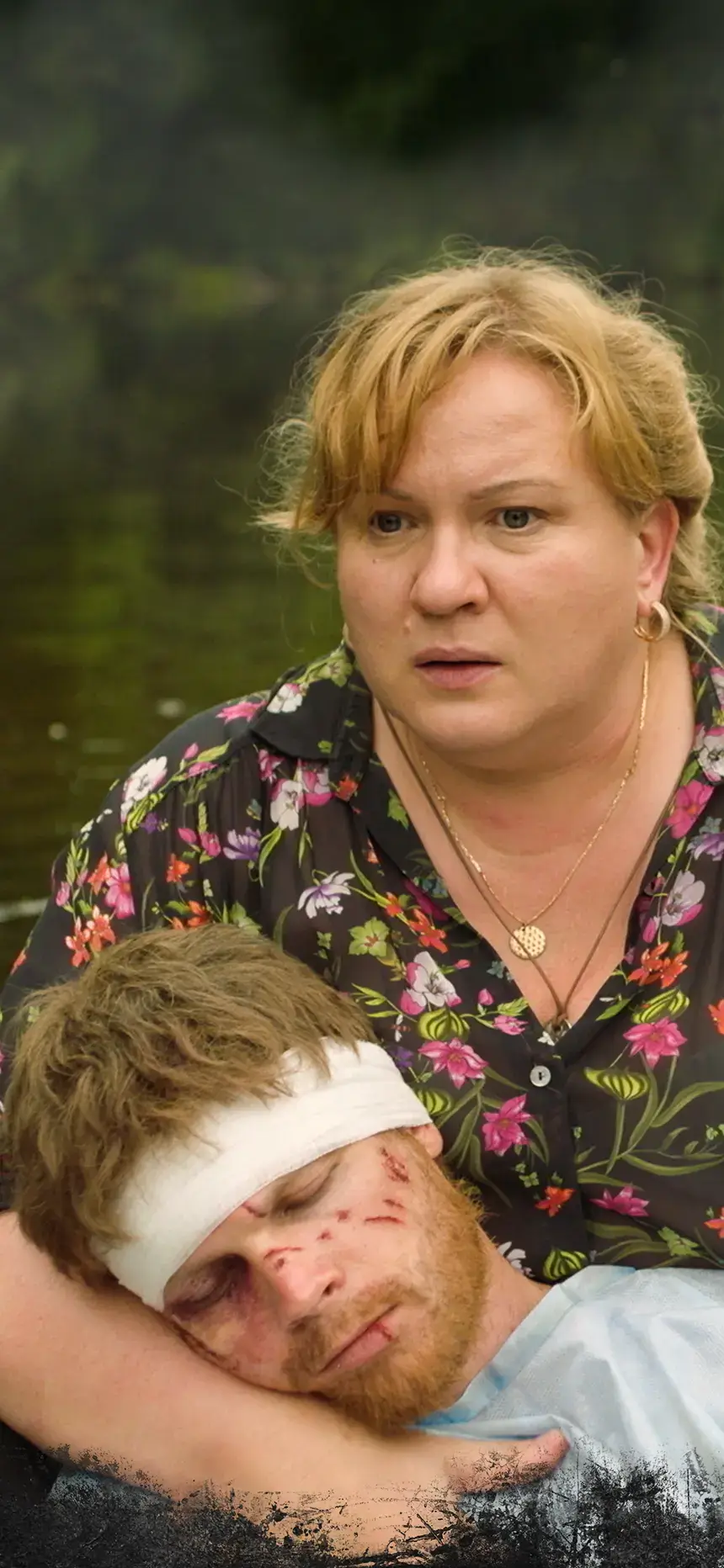 A distressed Ukrainian woman holds an IV bag above a wounded son in a boat.